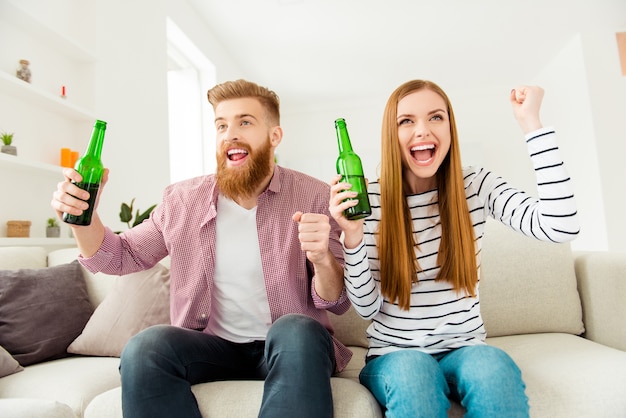 Couple at home watching tv together and having beer