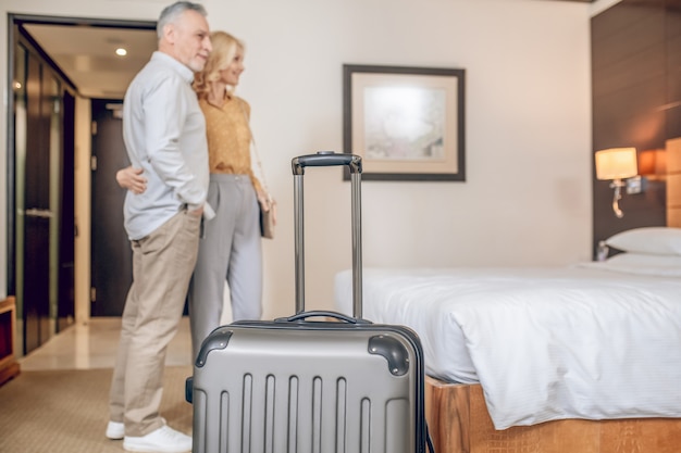 Couple in a hotel. Mid-aged couple in a hotel room looking contented