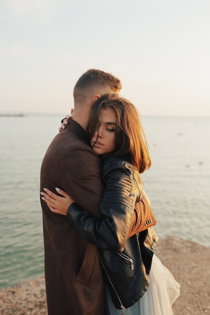 couple hugging on the beach at sunny day with sea on background.