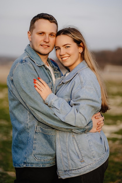 Couple hugging in a field with the sun behind them