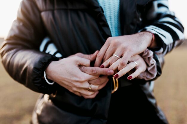 Photo couple hugging and holding hands with engagement rings