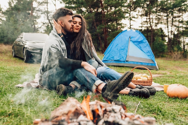 Couple hugging near campfire