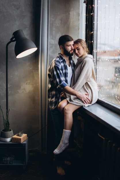 Couple hugging near a window