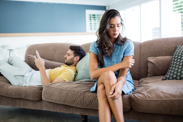 Couple ignoring each other in living room at home