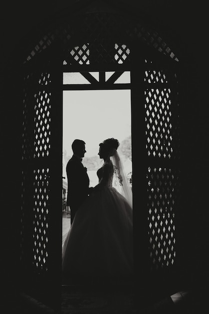 Photo a couple is standing in front of a door with the man wearing a suit