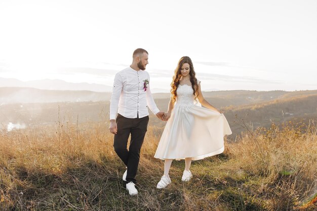 Photo a couple is walking on a grassy hillside with the man holding the womans hand