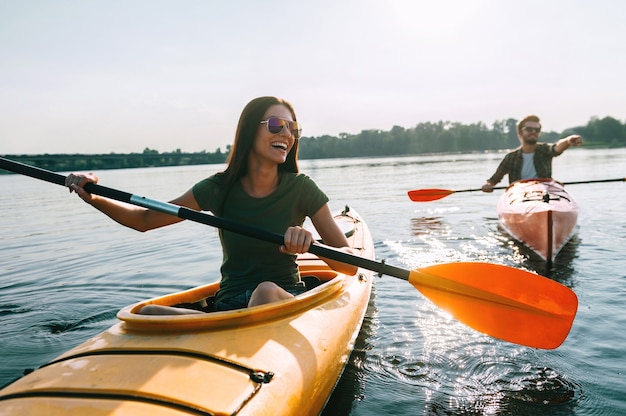 Couple kayaking together. Beautiful young couple kayaking on lake together and smiling