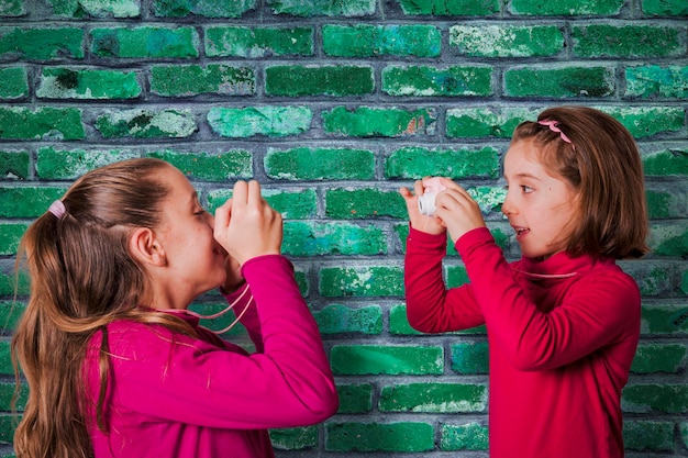 Couple of Little Girls Taking Picture Using Toy Photo Camera