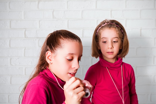 Couple of Little Girls Taking Picture Using Toy Photo Camera