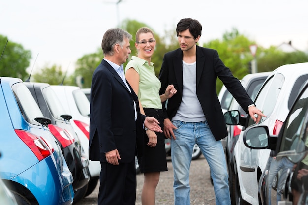 Couple looking at car on yard of dealer