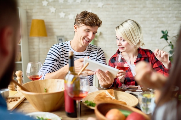 Couple Looking Using Digital Tablet at Dinner