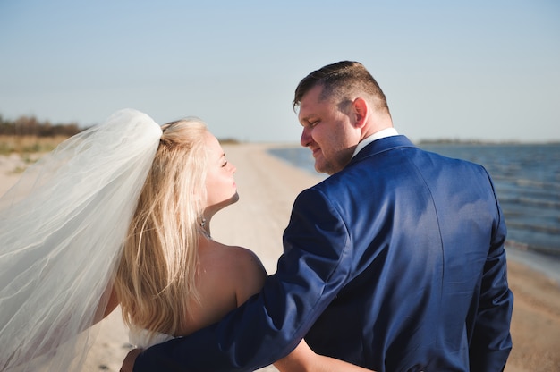 Couple in love on the beach on their wedding day.