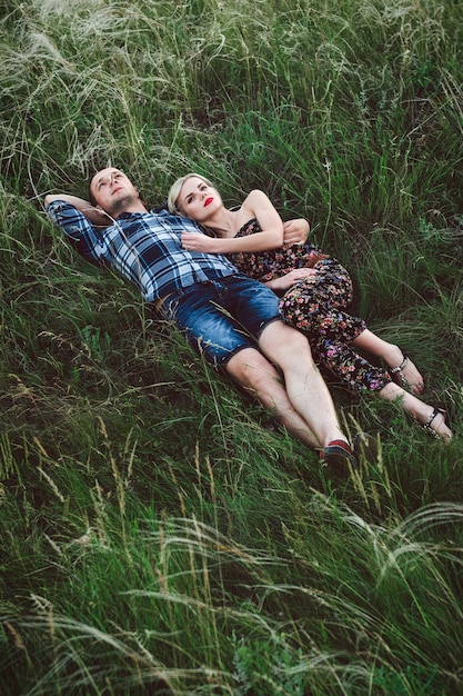 Couple in love blonde girl and guy in the grass