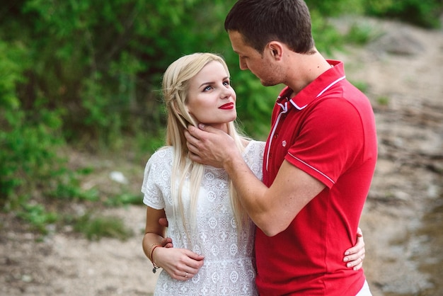 Couple in love blonde girl and guy on the river bank