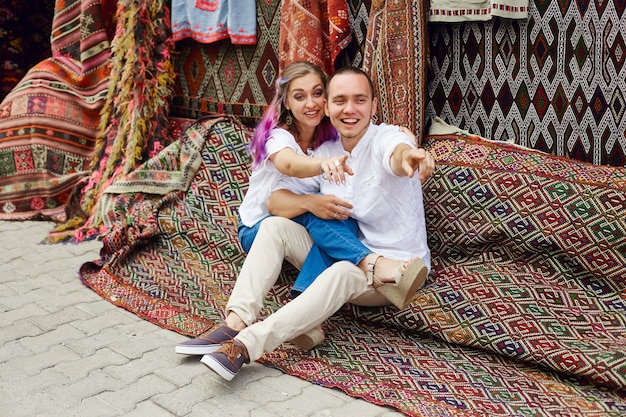 Couple in love buys a carpet and handmade textiles at an oriental market in Turkey. Hugs and cheerful happy faces of men and women