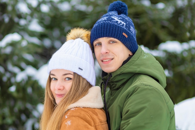 Couple in love celebrate valentine's day, christmas, new year. guy girl hugging in winter holiday, in wintertime on frosty snowy day