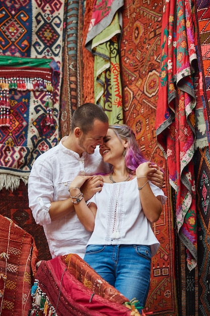 Couple in love chooses a Turkish carpet at the market. Cheerful joyful emotions on the face of a man and a woman. Valentines Day in Turkey