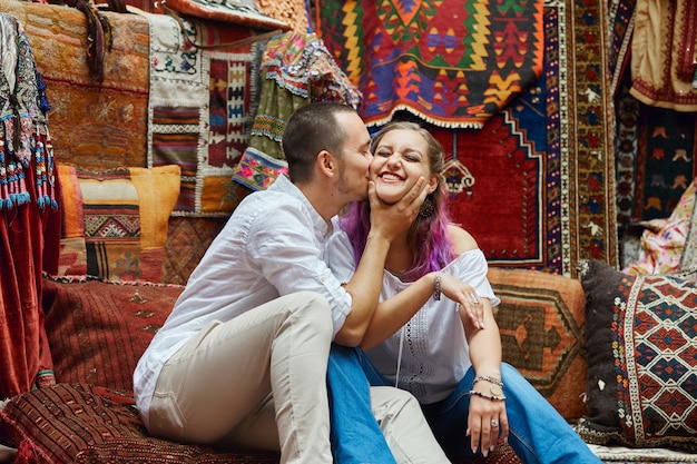 Couple in love chooses a Turkish carpet at the market.