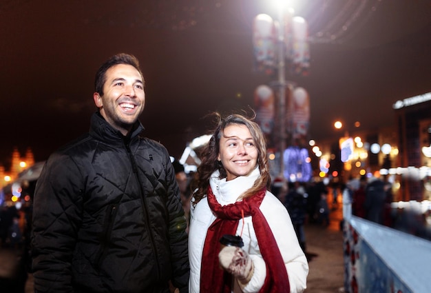 couple in love in the christmas evening in the city walking