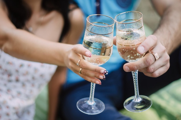 Couple in love in the forest holding glasses of wine