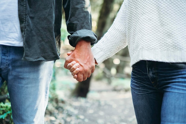 Couple in love holding hands and walking together in outdoor romantic leisure activity together Close up of man and woman keeping hands Romantic lifestyle and happy relationship moment Togetherness