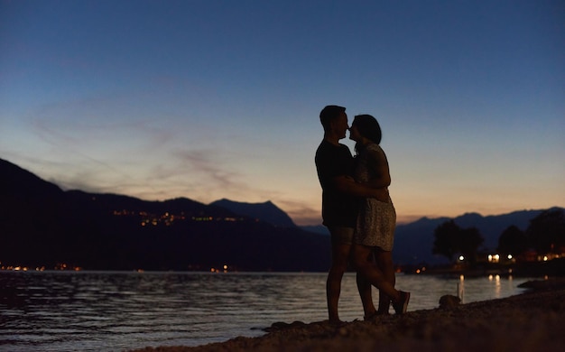 Couple in love hugging on the beach at night