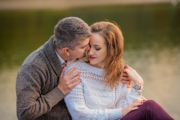 Couple in love hugging on the lake in autumn