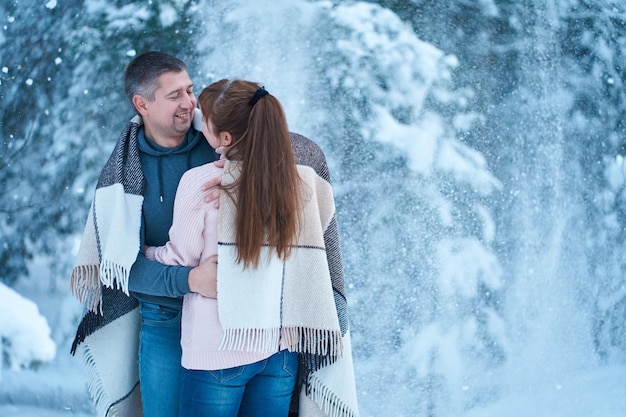 A couple in love kissing while walking through a fabulously snowcovered winter forest