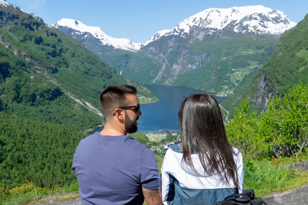 Couple in love looking at each other with the Geirangerfjord in the background on a sunny day