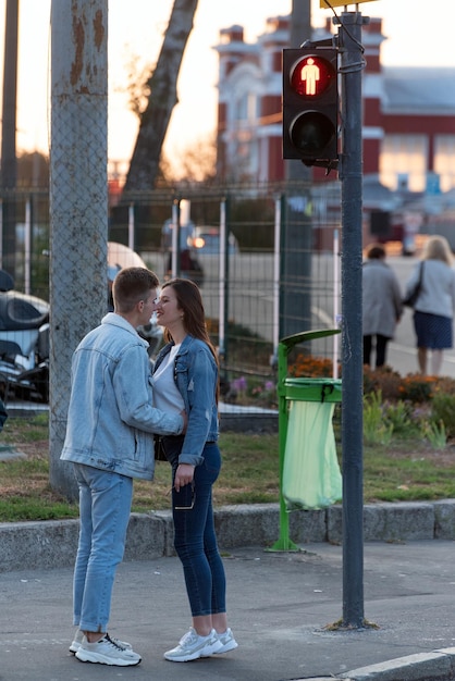 Couple in love met stands at traffic light and hugs Young lovers