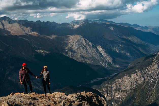 Couple in love in the mountains at sunset. Tourists on the tour. Couple in the Caucasus mountains, Russia. Man and woman at sunset. Tourists in the mountains, Dombay. Copy space