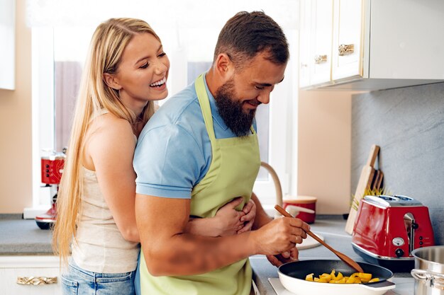 Couple in love preparing meal together in kitchen