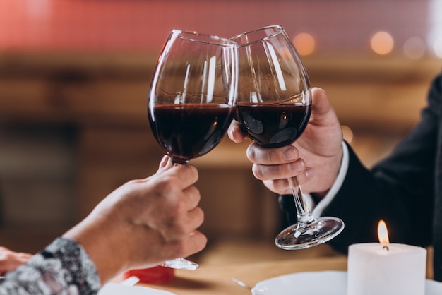 Couple in love raises glasses of red wine