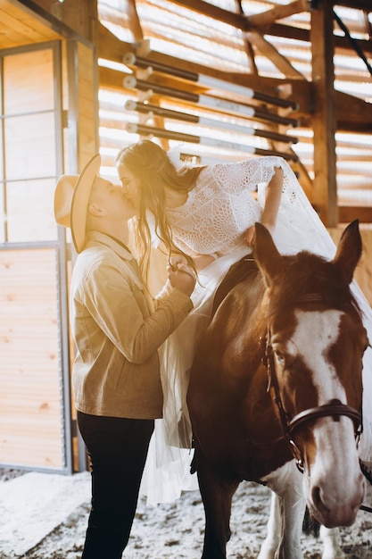 Couple in love riding horses on ranch at sunset in winter