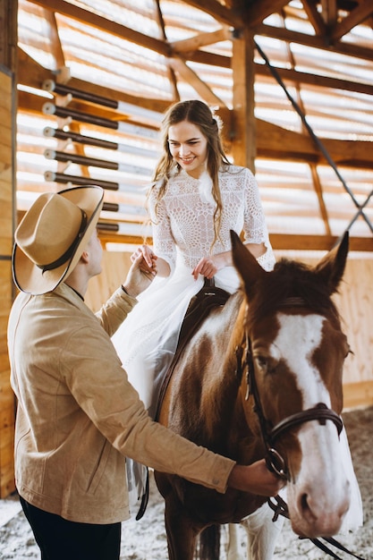 Couple in love riding horses on ranch at sunset in winter