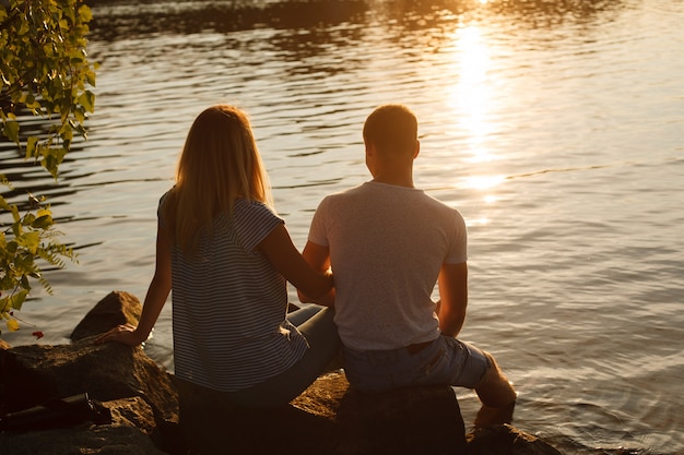 couple in love on a rocky shore at sunet in summer evening. concept love story outdoor. family weekend in nature. happy family resting  outside.