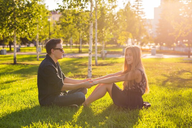 Photo couple in love sitting on the grass. love, relationship, friendship and leisure concept.