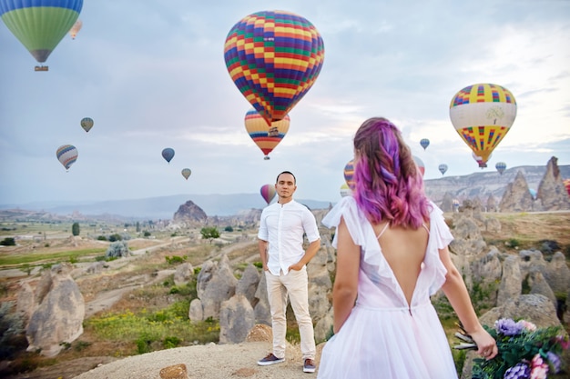 Couple in love stands on background of balloons in Cappadocia