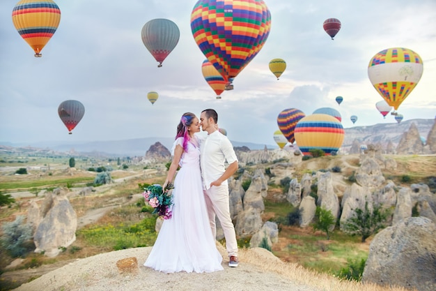 Couple in love stands on background of balloons in Cappadocia.