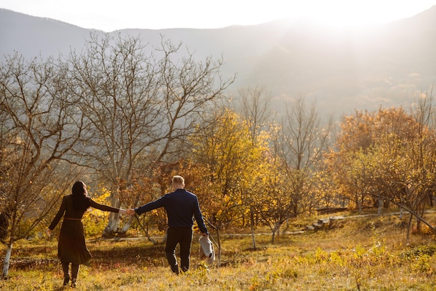 A couple of lovers are walking in the park holding each others hand