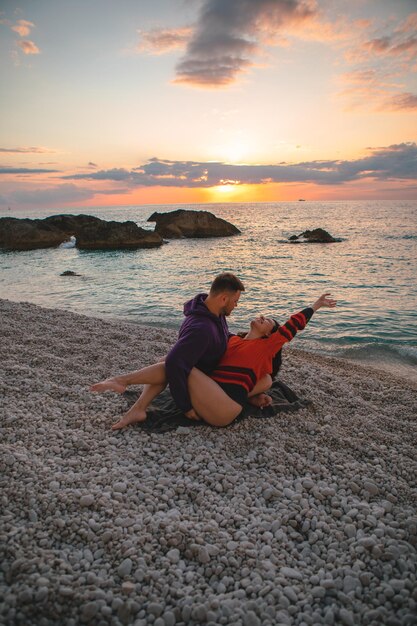 Couple lovers at the beach enjoying time together and sunset above the sea Greece vacation Lefkada island