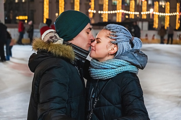 Couple of lovers hug and kiss on the rink on valentine's day or christmas.