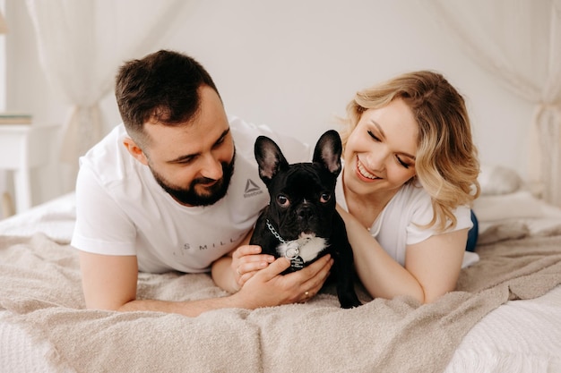 Couple lying in bed with a dog