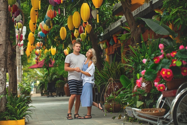 Couple a man and a woman travel together through the streets of an Asian city happy and beautiful