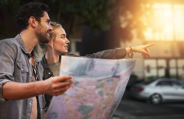 Photo couple map and point in street for travel direction and search for building on holiday in city people man and woman with paper chart for landmark location and outdoor on urban sidewalk in berlin