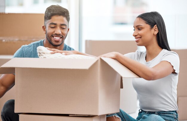 Couple moving boxes and new home or real estate investment or property milestone or future Man woman and happy in apartment unpacking as owner with mortgage for immigration finance or relocation