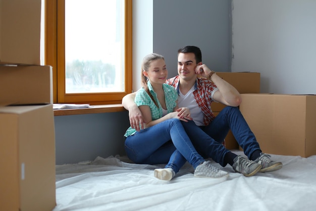 Couple moving in house sitting on the floor Couple