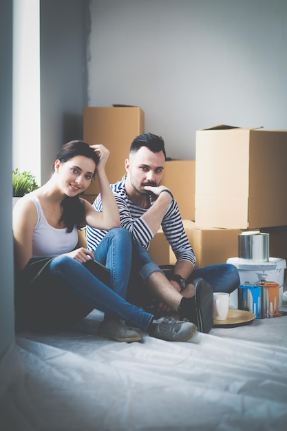 Couple moving in house sitting on the floor Couple