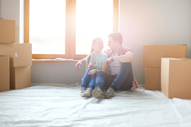 Couple moving in house sitting on the floor Couple