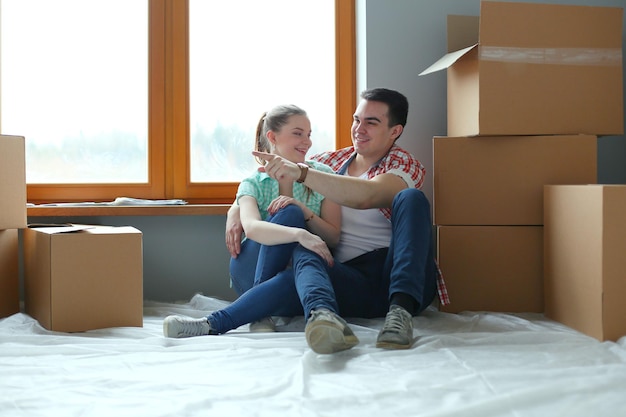 Couple moving in house sitting on the floor